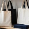 Bolsas de tela de algodon en crudo, negro y azul colgadas en un taller de serigrafia