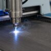 Maquina de grabado laser marcando un termo de acero inoxidable en un taller