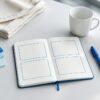 Escritorio con libreta de plan de marketing, marcador, taza, termo y bolsa de tela